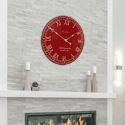 Red and white wall clock on light brick